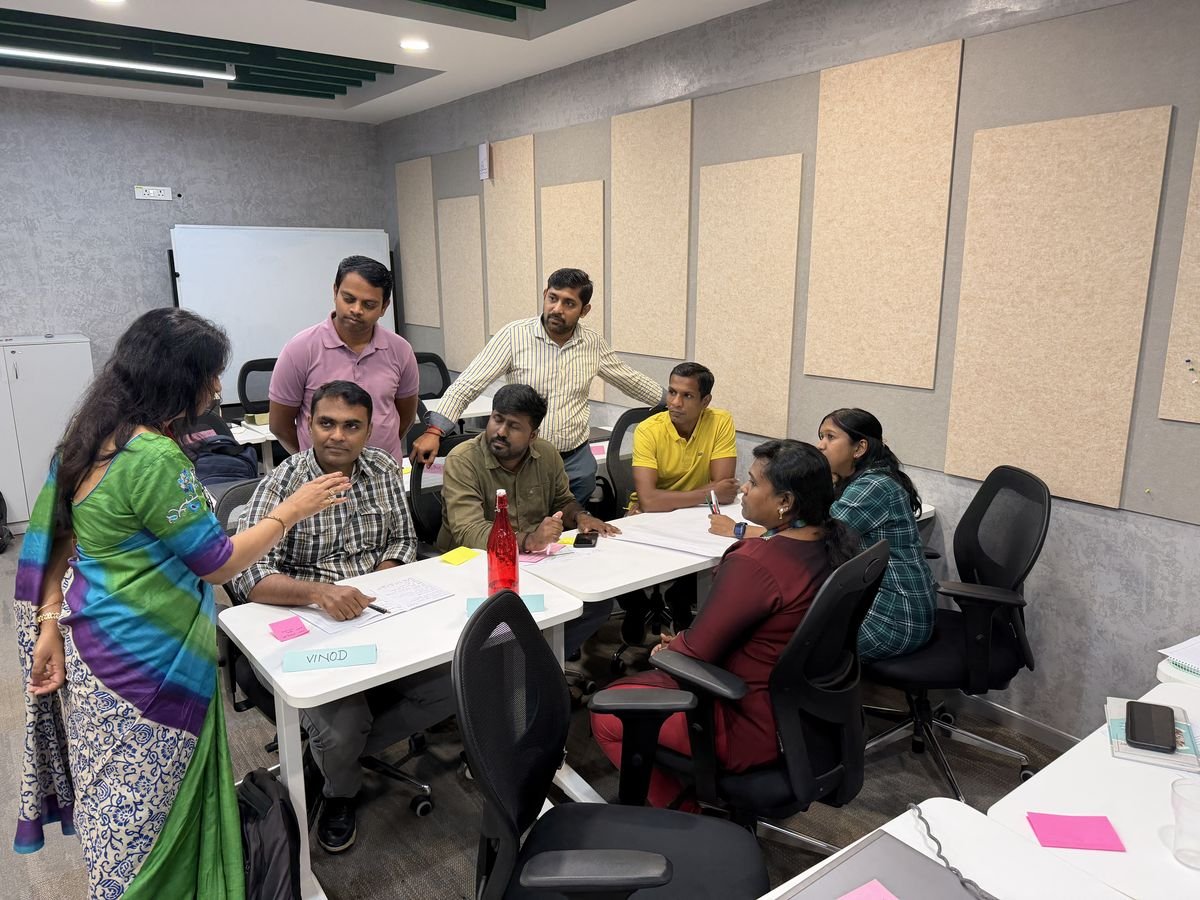 A Protocol trainer coaching a table group during a corporate workshop